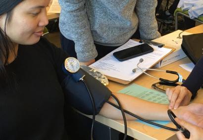 students practice taking blood pressure on each other