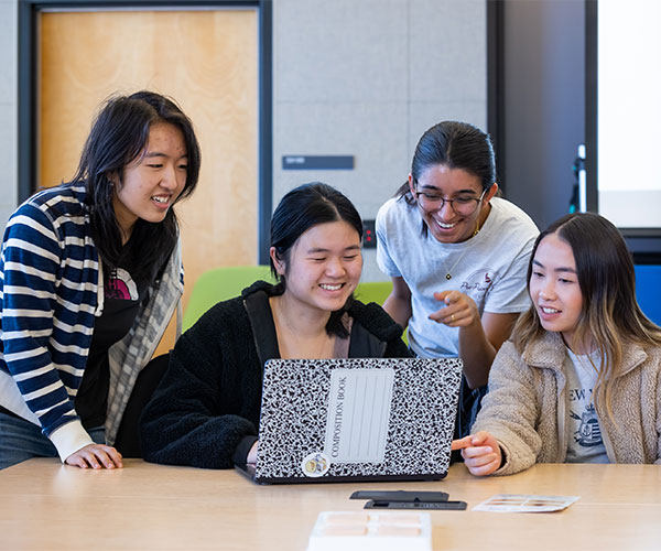 PharmD students look at a laptop in a classroom