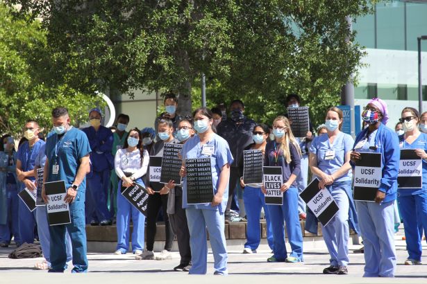 Health care workers standing at a rally