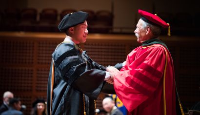 graduate and Guglielmo dressed in regalia