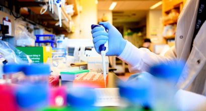 A researcher injects fluid into containers
