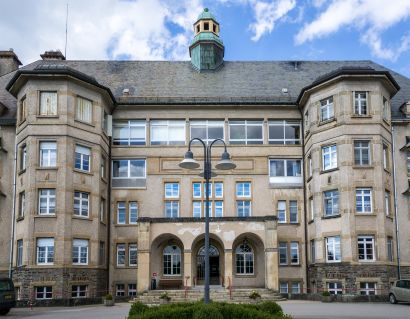 large, old building with five levels, two towers, pitched roof, and cupola