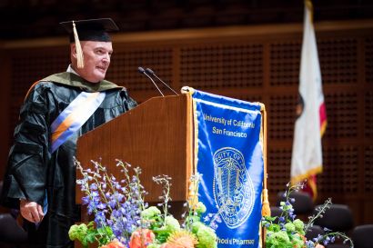 Stimmel dressed in regalia at podium