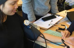 students practice taking blood pressure on each other