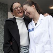 Mother and daughter on steps, laughing