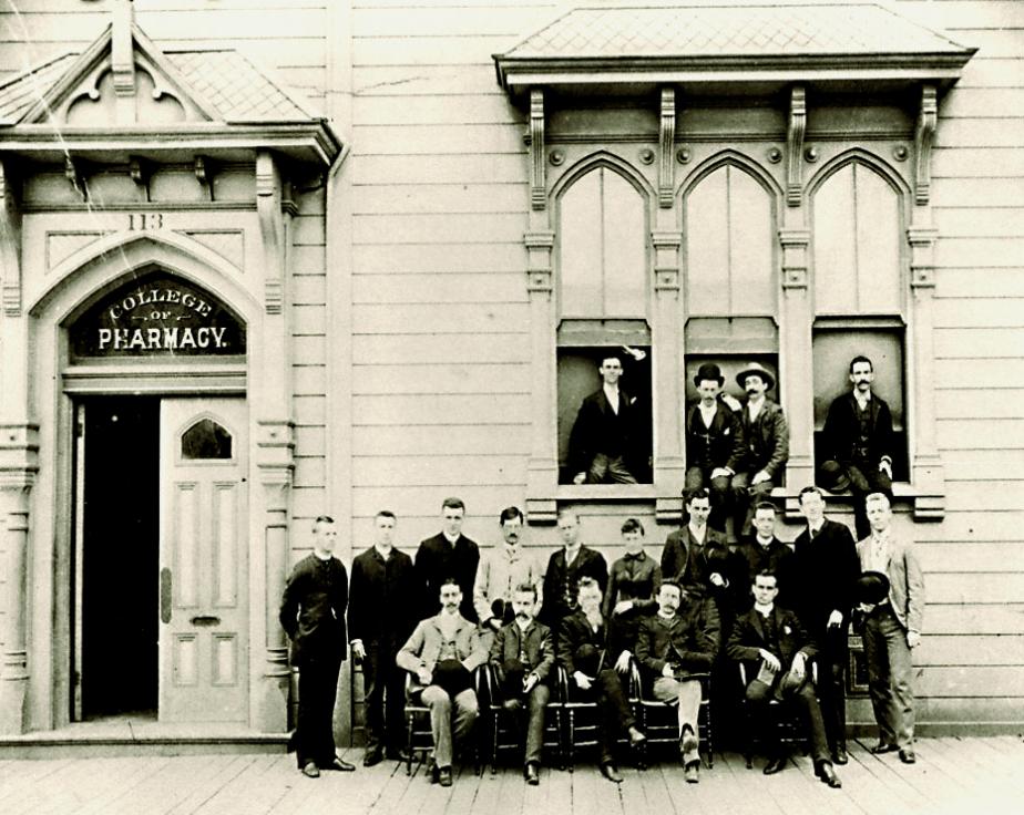 group poses in front of Victorian building.
