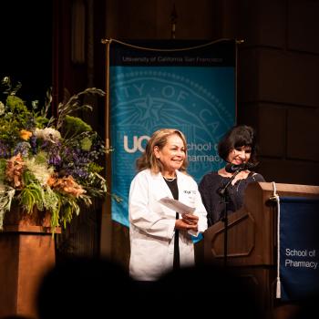Salda&ntilde;a and Giacomini stand at lectern