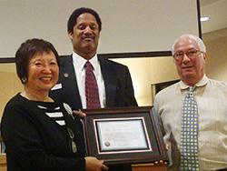 Koda-Kimble holds award with Schell and Weisser.