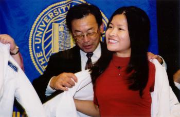 Kishi helps student with white coat