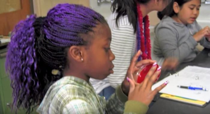 girl looking at petri dish