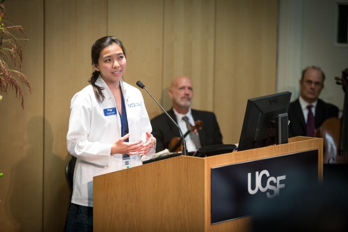 Chen at podium in white coat.
